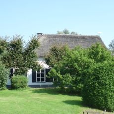 Boerderij "Middenrust" : fraai witgepleisterd groot dwarshuistype, zadeldak met een topgevel eindigend, opkamer