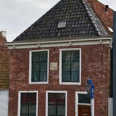 Pand met gevelsteen met paard onder schilddak met topschoorsteen