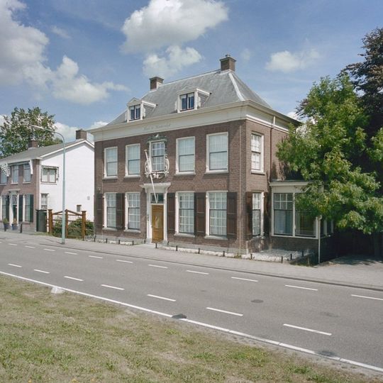 Huis te Kinderdijk. Deftig herenhuis van parterre en verdieping, ter breedte van vijf vensterassen. Dwars schilddak met schoorstenen en dakkapellen