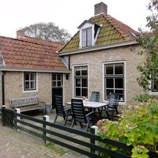 Pand zonder verdieping onder met pannen gedekt afgewolfd zadeldak