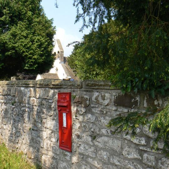 West wall to churchyard of Church of St Illtyd with stile, gatepiers and postbox