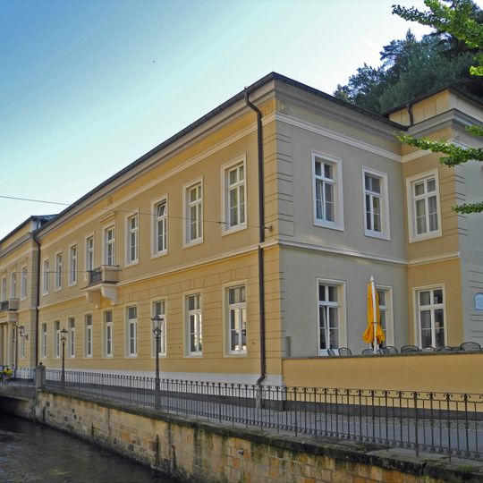 Kurbadgebäude, Trinkhalle mit Monumentalmosaik, vor dem Gebäude Freiskulptur der Waldnymphe sowie Kurgarten mit Denkmal für die Gefallenen des Ersten Weltkrieges Kirnitzschtalstraße 6