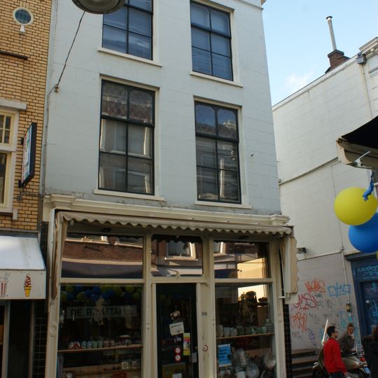 Hoekpand Vriesestraatsteiger met hoog schilddak waarin dakvenster; gepleisterde voorgevel met decoratie. Puntgevel aan de Voorstraatshaven