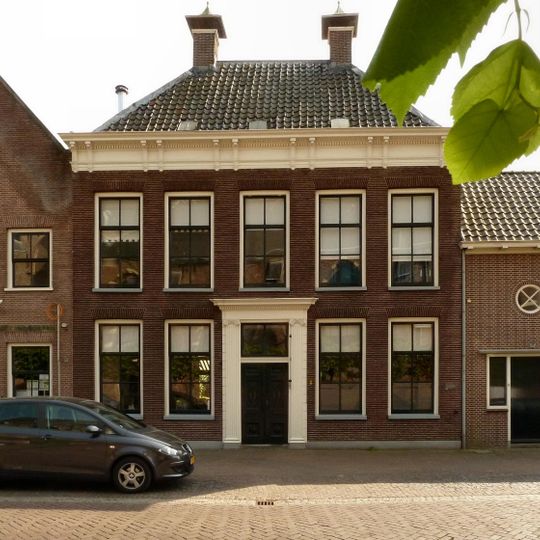 Gaaf bewaard, deftig herenhuis met verdieping en dwars schilddak, waarop hoekschoorstenen met kappen