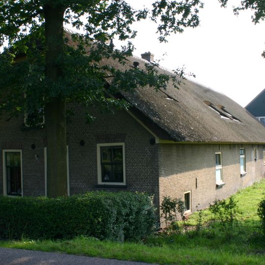 Boerderij uit het derde kwart van de 19e eeuw. Rieten wolfdak, voorgevel met vlechtingen en vensters met 6-ruitsschuiframen uit de bouwtijd