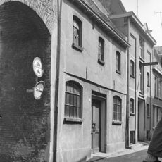 Pakhuis met aan de gasthuissteeg een puntgevel met ezelsruggen en bakstenen tweelichtskozijnen