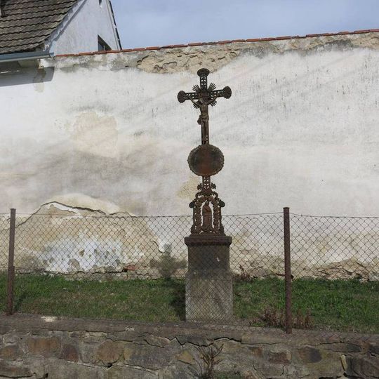 Kříž u zdi statku v Pořešíně