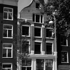 Pand met lisenengevel, versierd met grote boogblokken onder rollagentop