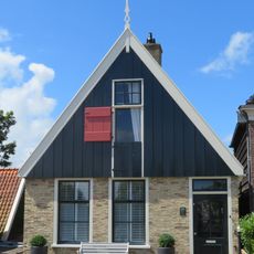 Pand onder zadeldak tegen topgevel met houten voorschot: in de top houten makelaar