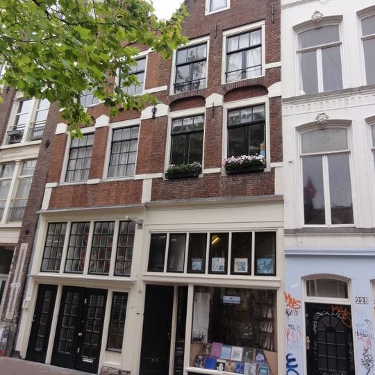 Pand met gevel, versierd in de trant met grote boogblokken onder rollagentop