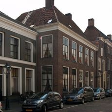 Pand met brede bakstenen gevel, rechte kroonlijst en voordeur met gesneden bovenlicht