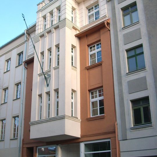 Mietshaus in geschlossener Bebauung, mit Laden und Fahnenhalter Friedrichsstraße 4