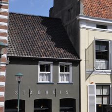 Rechts naast het stadhuis een klein pand onder een zadeldak, vermoedelijk laat-middeleeuws