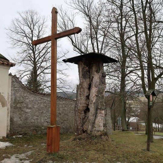 Dřevěný kříž před kostelem v Mrtníku