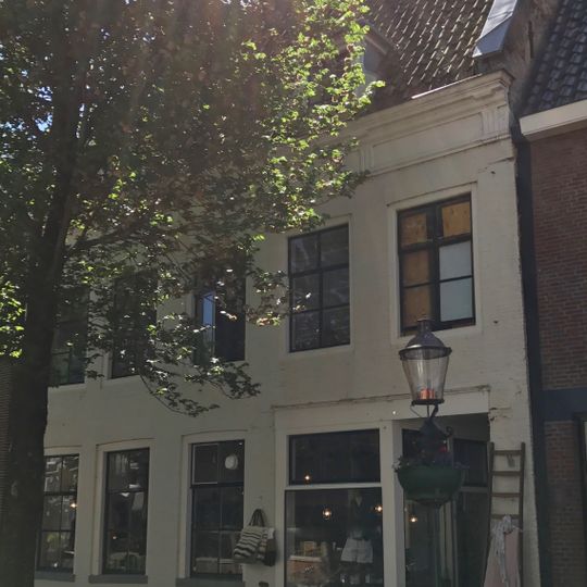 Vijf traveeën breed pand tussen topgevels met rechte kroonlijst met trigliefen onder dwars zadeldak met twee dakkapellen