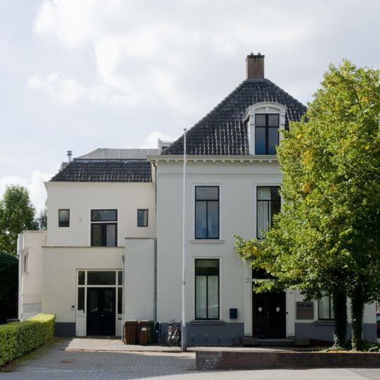 Groot huis met witgepleisterde lijstgevel