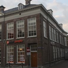 Ruim hoekpand van fijn metselwerk met zware geblokte kroonlijst met timpaan