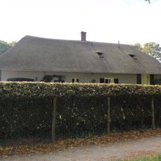 Boerderij onder met riet en pannen gedekt wolfdak, verbouwd tot bungalow, waarbij het historische karakter goed bewaard is gebleven