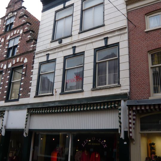 Pand met brede trapgevel in haarlemse trant met natuurstenen blokken in bogen boven ramen en horizontale banden