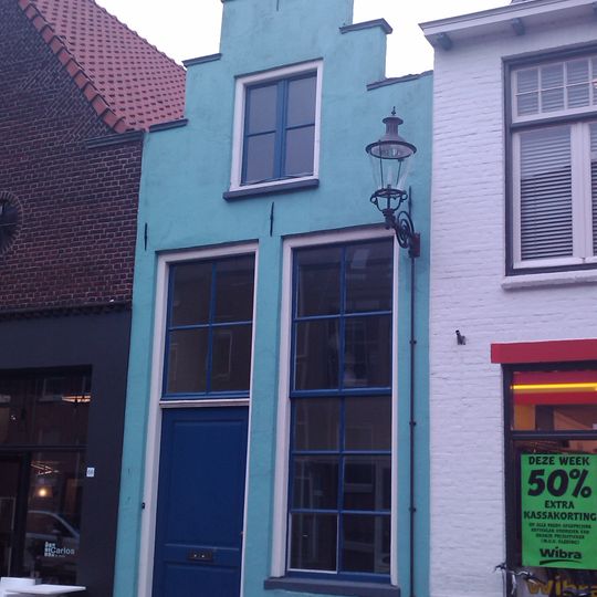 Onderkelderd gepleisterd huis met trapgeveltje