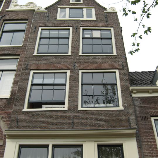 Huis met latere gevel, bekroond door een klokvormige top onder rollagen