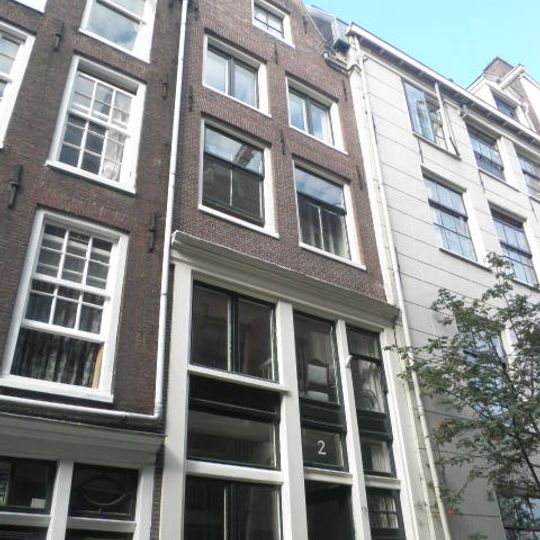 Huis met lagere gevel onder klokvormige top met rollagen