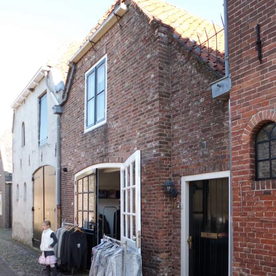 Woonhuis met afgewolfd schilddak en gepleisterde gevel onder rechte lijst