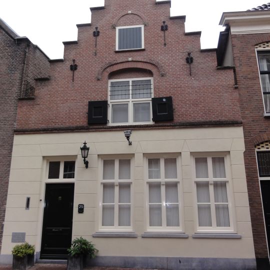 Huis met topgevel met ontlastende korfboog om bovenvenster