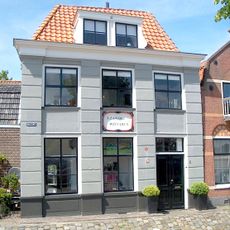 Gepleisterd hoekpand met verdieping en schilddak