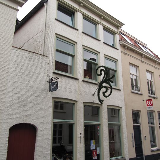 Huis met lijstgevel van roodgeverfde baksteen en met schilddak