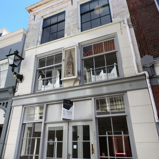 Huis met lijstgevel. Dakkapel. Moderne winkelpui.