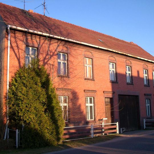 Bauernhof mit westlichem Wohnhaus und drei Seitengebäuden eines geschlossenen Vierseithofes sowie östlich dahinterliegender Feldscheune Dorfstraße 28