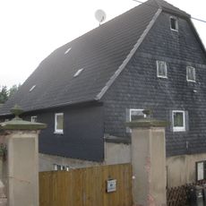 Wohnstallhaus und Einfriedungsmauer mit Toreinfahrt eines ehemaligen Dreiseithofes Ortelsdorfer Straße 21