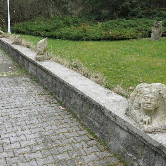 Drobné kamenné plastiky na zídce nádvoří nového pavilonu Prusíkova pramene v Konstantinových Lázních