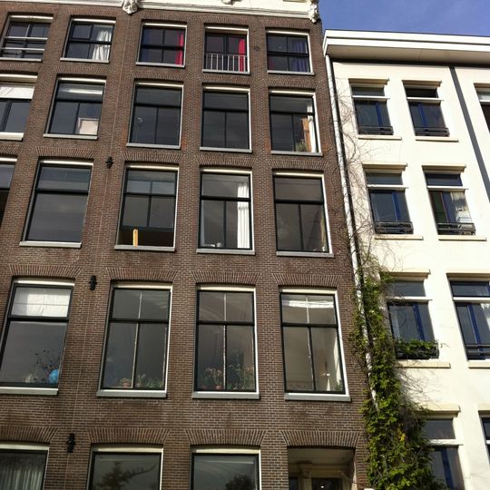 Pand met gevel onder verhoogde gesneden lijst met kuif