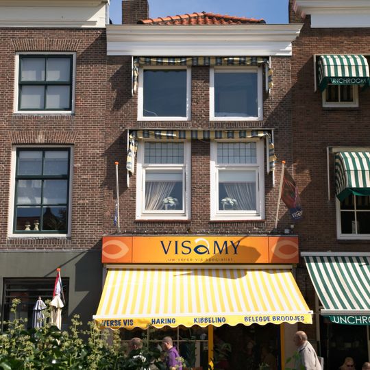 Huis met eenvoudige 19e-eeuwse lijstgevel. Moderne winkelpui