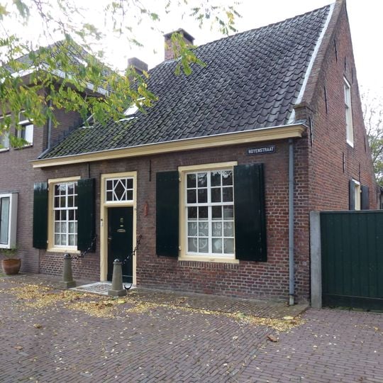 Dorpswoning onder met pannen belegd zadeldak tegen een zijtopgevel