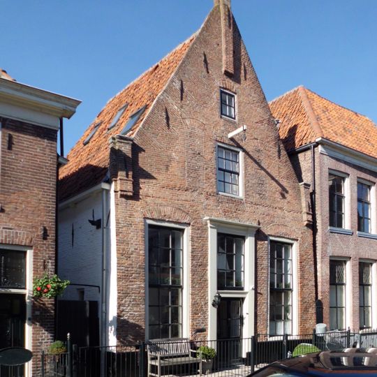 Huis met puntgevel met toppilaster en hoekpilasters onder aan de top