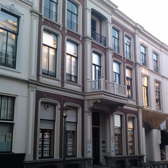 Pand dat deel uitmaakt van een in het derde kwart van de 19e eeuw als een symmetrisch geheel ontworpen straatwand