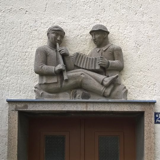 Vier Reliefplatten über den Hauseingängen einer Wohnhauszeile, Gebäude selbst keine Denkmale An der weißen Mauer 22, 24, 26, 28