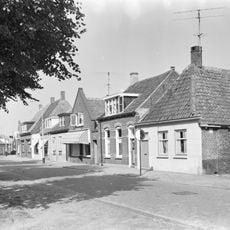 Dorpshuisje, onder pannendak met voorschild. Schuifvensters in zijgevel