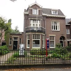Halfvrijstaand herenhuis met oorspronkelijk smeedijzeren hekwerk rond de voortuin