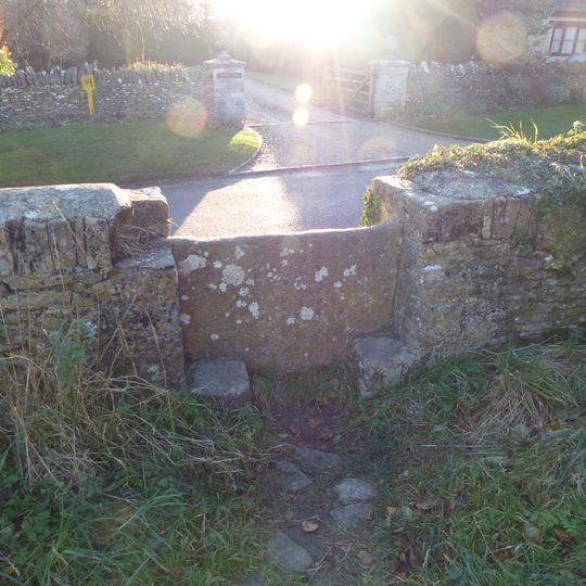 Stone stile and attached wall about 5 1/2 metres long, adjoining on east of wall of Quenington House