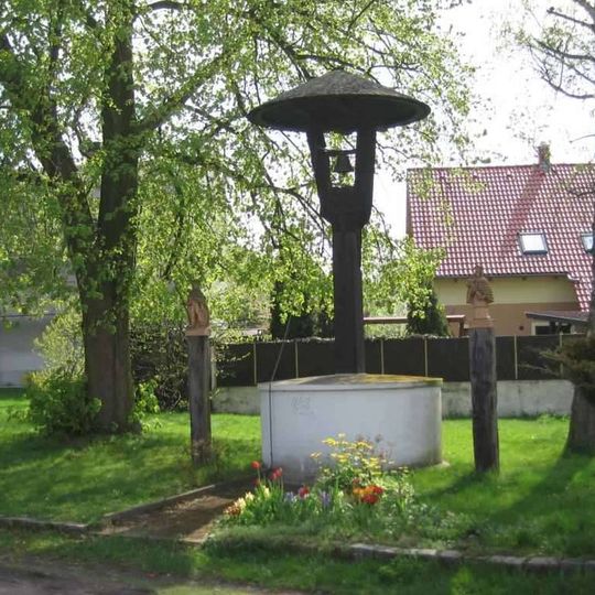 Krytá dřevěná zvonička ve středu obce Klučov