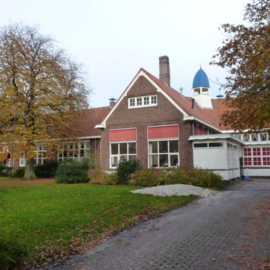 Schoolgebouw in regionale Amsterdamse Schoolstijl met Engelse landhuisstijl-elementen