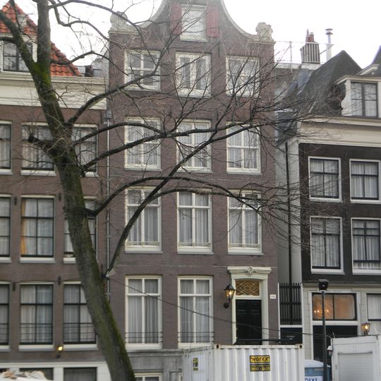 Pand met klokgevel met deur en snijraam hek in gesneden omlijsting