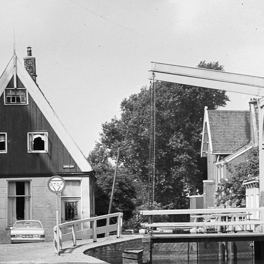 Huis met houten topgevel boven een gepleisterde bakstenen pui