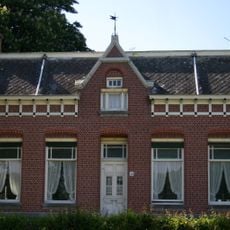 Boerderij, bestaande uit een woonhuis met aangebouwd bedrijfsgedeelte, gebouwd op een kunstmatige verhoging. In de gevel van het huis zijn elementen van Neo-Renaissance verwerk