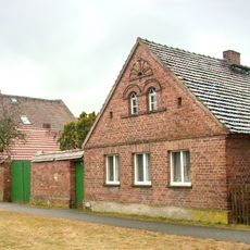 Bauernhof mit Wohnhaus, Seitengebäude und Scheune sowie Hofmauer Dorfaue 11