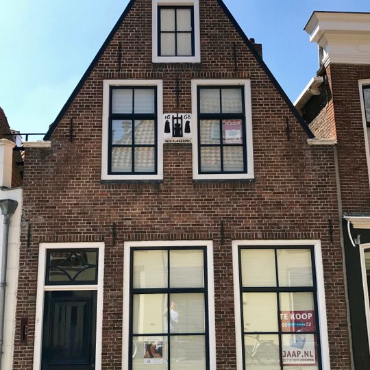 Pand onder zadeldak tegen smalle puntgevel, afgedekt door houten lijsten